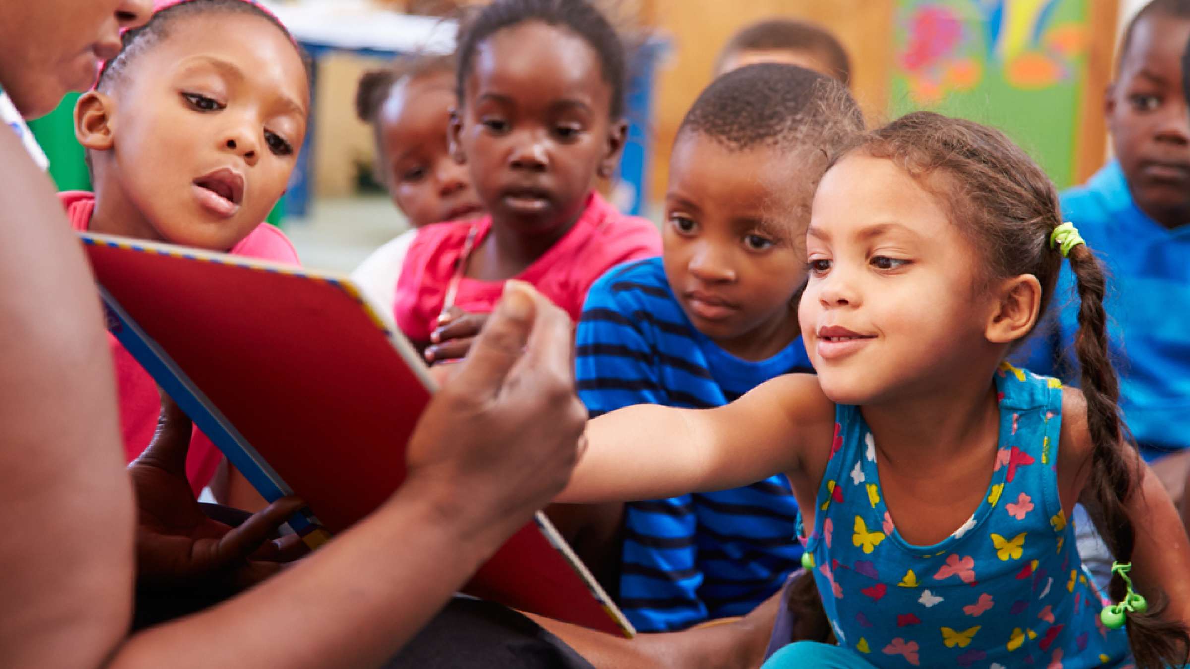 Teacher read a book with a class of pre-school children