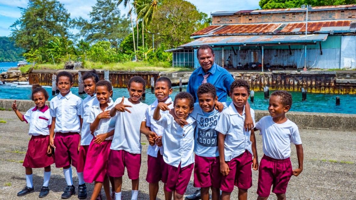 Local school children on tropical island with their teacher