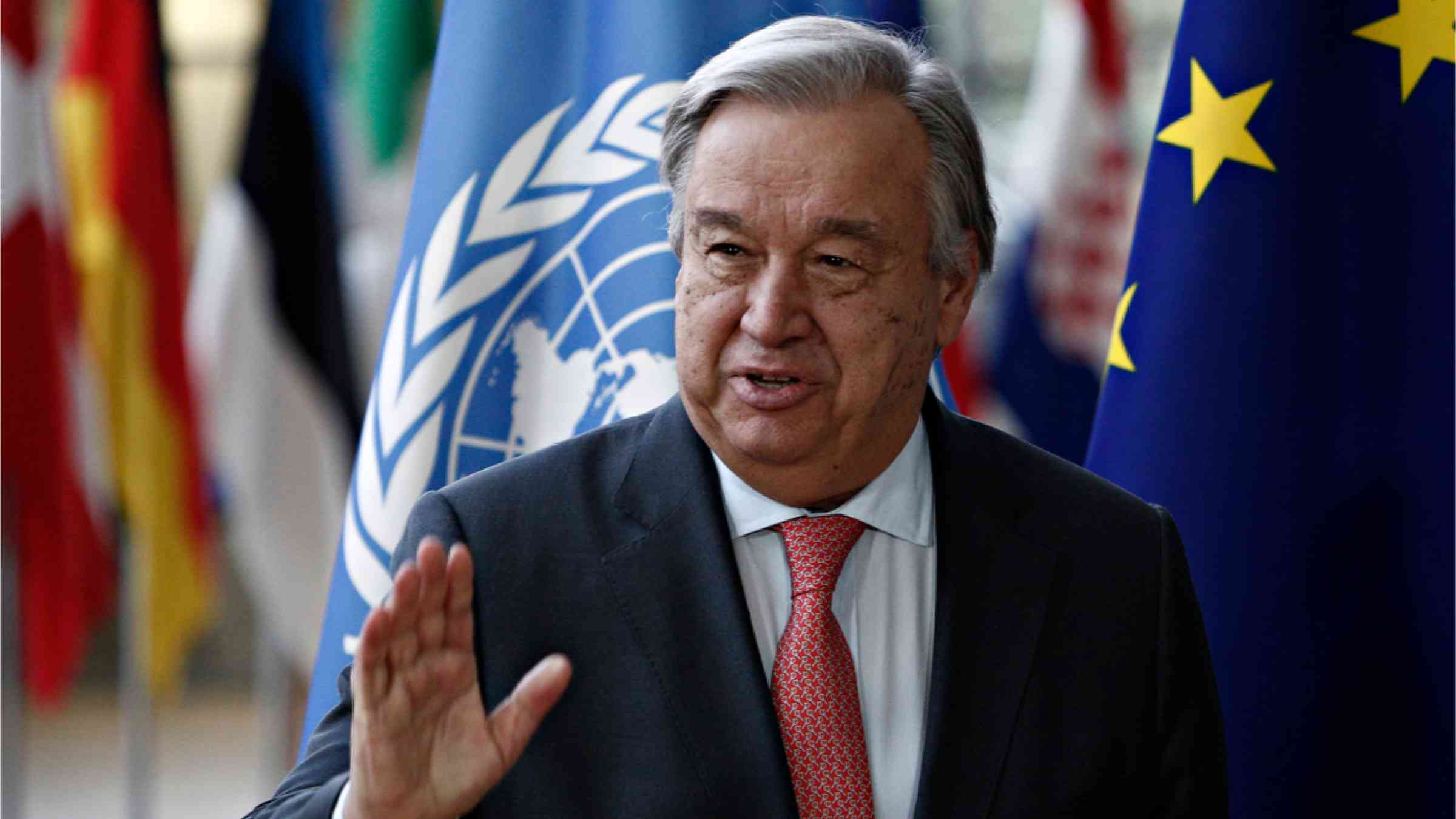 U.N. Secretary-General Antonio Guterres in front of the UN flag and national flags 