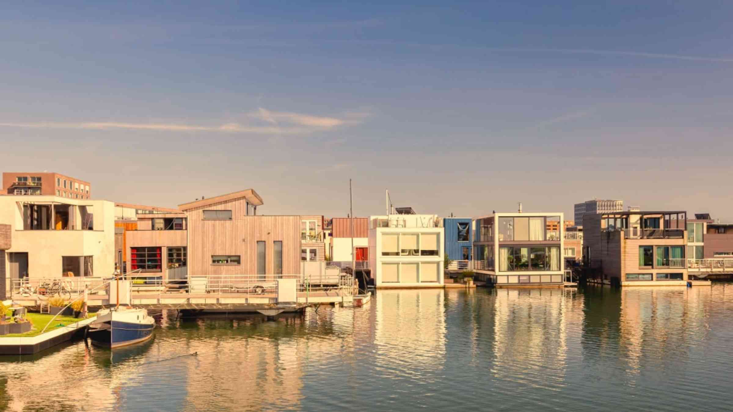 Row of contemporary houseboats in IJburg district at sunset in Amsterdam, Netherlands.