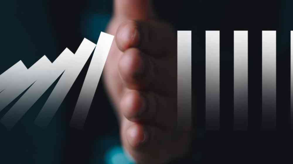 Business's hand holding a glowing domino