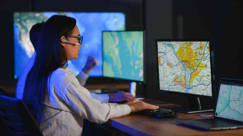 Woman in front of screen monitoring transport processes.