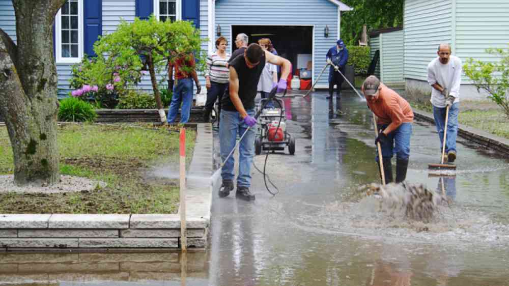 Richelieu Valley, Quebec, Canada June 11, 2011:  Volunteers cleanup outside of a suburban home follow catastrophic flooding