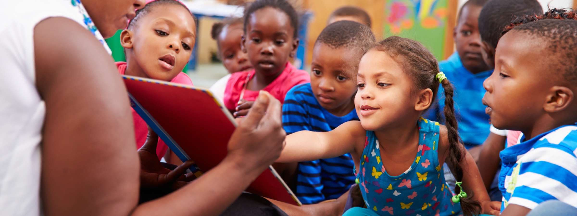 Teacher read a book with a class of pre-school children